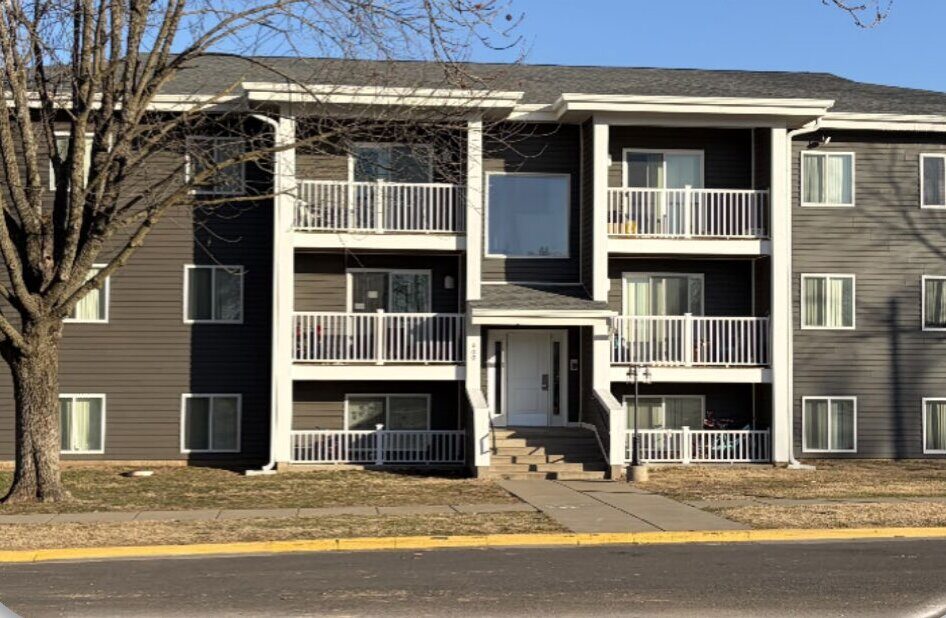 Sycamore Village, Pittsburg, KS — the renovated building with dark siding and new balconies